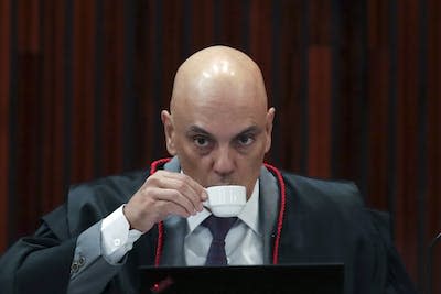 Alexandre de Moraes, head of Brazil’s electoral court, sips coffee during Jair Bolsonaro’s trial at the Supreme Court in Brasilia, Brazil, in June 2023. (AP Photo/Gustavo Moreno)