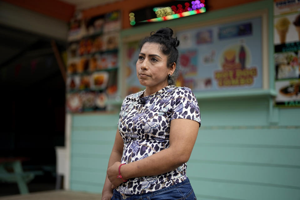 Manuela Lara talks about the area while standing in front of her food stand Tuesday, May 2, 2023, in the neighborhood where a mass shooting occurred last week, in Cleveland, Texas. As the victims were remembered for their efforts to seek better lives in the U.S. or for their bravery in saving children during the shooting, neighbors are uncertain if they and the community they’ve worked hard to build would ever recover. (AP Photo/David J. Phillip)