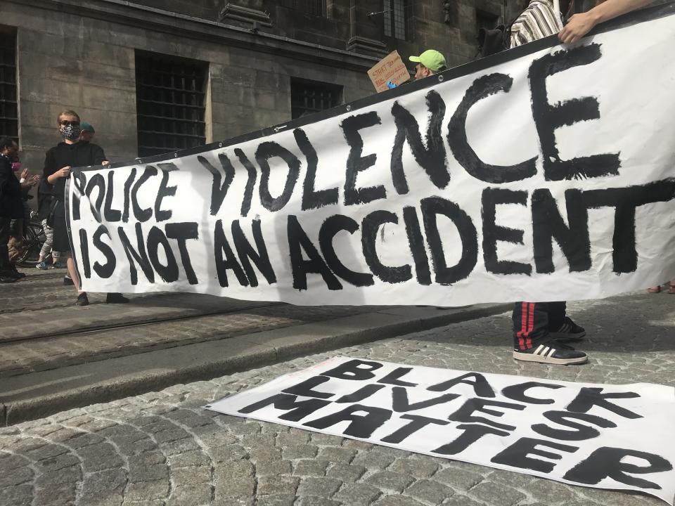 <i>People shout slogans during a June 1 protest at Dam Square in Amsterdam over the death of George Floyd. The banner reads: "Police violence is not an accident." </i>