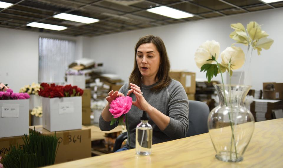 Liz Carter of Unwilted in Holt fluffs one of her paper flowers with isopropyl alcohol Thursday, Nov. 11, 2021, at her workspace in Holt. Each flower is made from Italian crepe paper and crafted by hand from Carter's original designs.