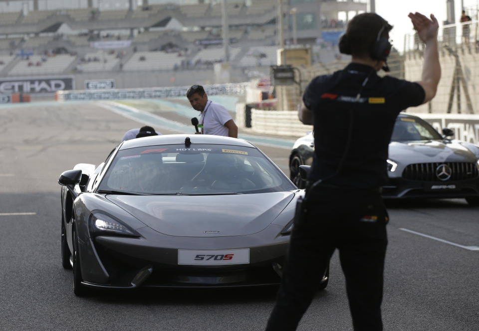 Mclaren driver Fernando Alonso of Spain, right, flanked by Nascar World champion Jimmie Johnson drive a McLaren 570S car at the Yas Marina racetrack in Abu Dhabi, United Arab Emirates, Saturday, Nov. 24, 2018. Seven-time NASCAR champion Jimmie Johnson and two-time Formula One champion Fernando Alonso drive Pirelli hot laps together around the Abu Dhabi F1 track on Saturday afternoon. (AP Photo/Luca Bruno)