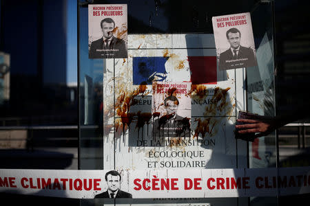 Environmental activists block the entrance of the Ministry of Ecology, Energy and Sustainable Development during a "civil disobedience action" to urge world leaders to act against climate change, in La Defense near Paris, France, April 19, 2019. The slogan reads " Macron, President of polluters". REUTERS/Benoit Tessier