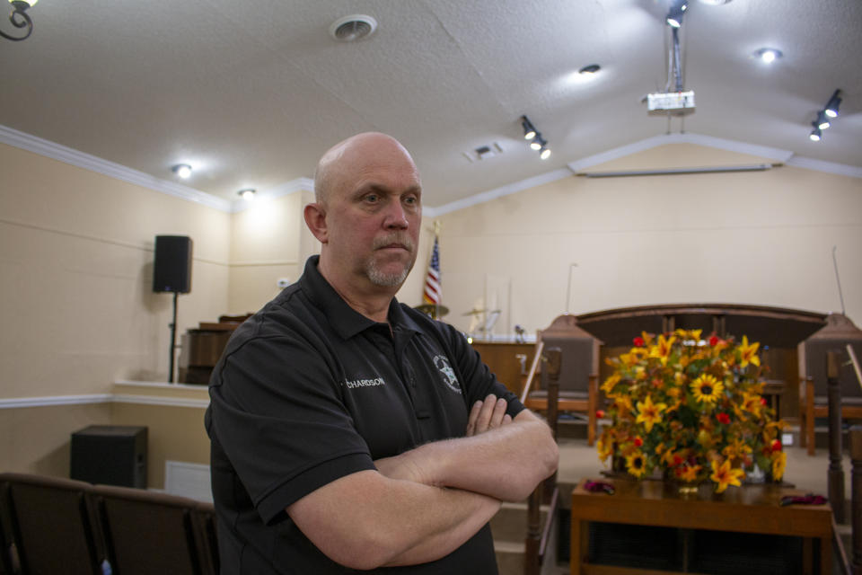 In this Oct. 17, 2019 photo, the Rev. Tommy Richardson, who serves as the chaplain for the sheriff's department, poses in Baker County, Fla. Richardson says his community is a forgiving place. Some Baker County residents express compassion for a teenager who wrote a school shooting plan and says he is in need of help. They are showing less mercy for a judge who released him without requiring mental health services, saying she failed their community and the boy she spared. (AP Photo/Bobby Caina Calvan)