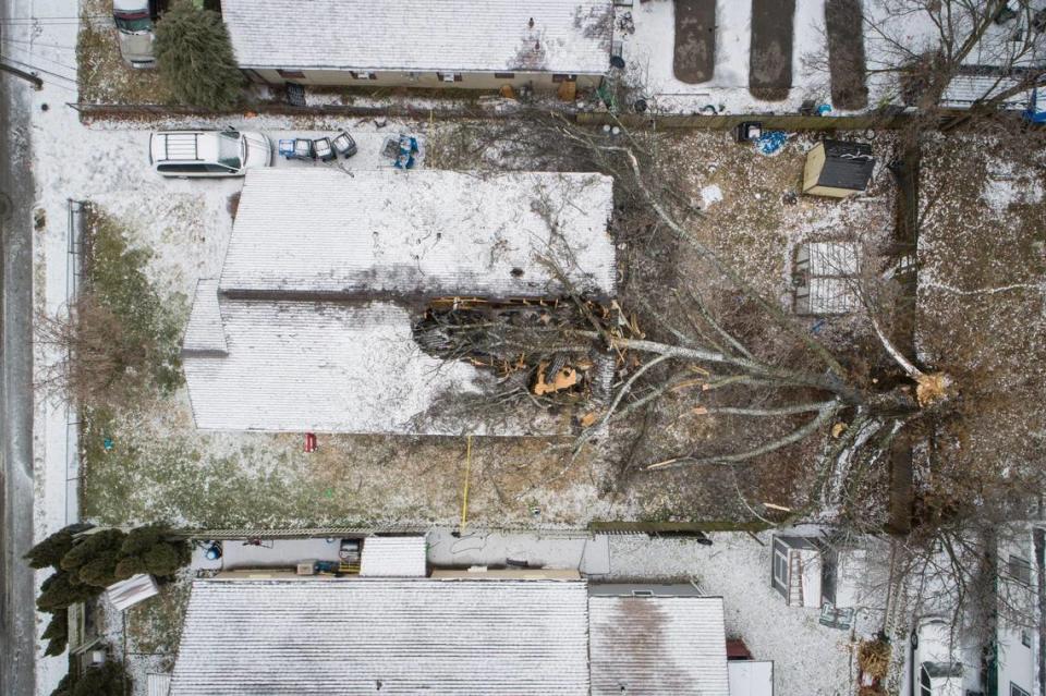 A downed tree lays across a home at 171 East Sixth Street following an ice storm Lexington, Ky., Thursday, Feb. 11, 2021. Occupants living at the home were not hurt when the tree fell. Thousands of people lost power.