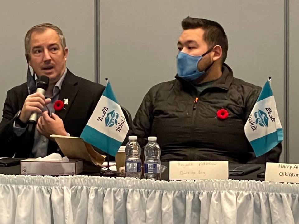 Iqaluit Mayor Kenny Bell, left, and newly appointed Cambridge Bay Mayor Angulalik Pedersen speak in November to members of the Nunavut Association of Municipalities during their annual general meeting in Iqaluit. Cambridge Bay residents say they&#39;re concerned by Angulalik&#39;s appointment. (Jane George/CBC - image credit)