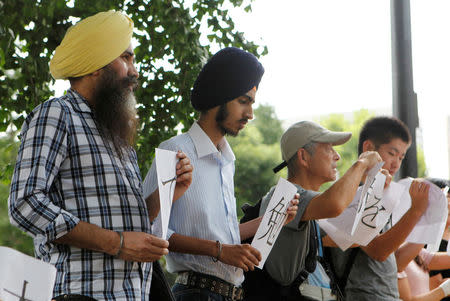 Gursewak Singh (2nd L) and his father, Bharpoor Singh, (L) take part in a protest calling for visas for children on provisional release in front of the Ministry of Justice in Tokyo, Japan, August 24, 2016. REUTERS/Thomas Wilson