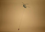 <p>A helicopter with a water bucket flies through dense smoke near Stevenson, Wash., on Sept. 6, 2017, as it works to battle the Eagle Creek wildfire on the Oregon side of the Columbia River Gorge. (Photo: Randy L. Rasmussen/AP) </p>