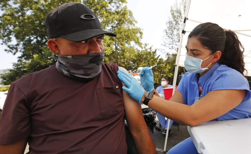 LOS ANGELES, CA - JULY 23: Marco Figueroa, 42, gets the Pfizer vaccine from Registered Nurse Jonica Portillo at the Pico Union Project located at 1153 Valencia where Curative is offering Covid testing and a choice of Pfizer or Johnson and Johnson Covid vaccine on Friday morning. We're asking the few that attended what has finally motivated people to get vaccinated. Pico Union Project on Friday, July 23, 2021 in Los Angeles, CA. (Al Seib / Los Angeles Times).