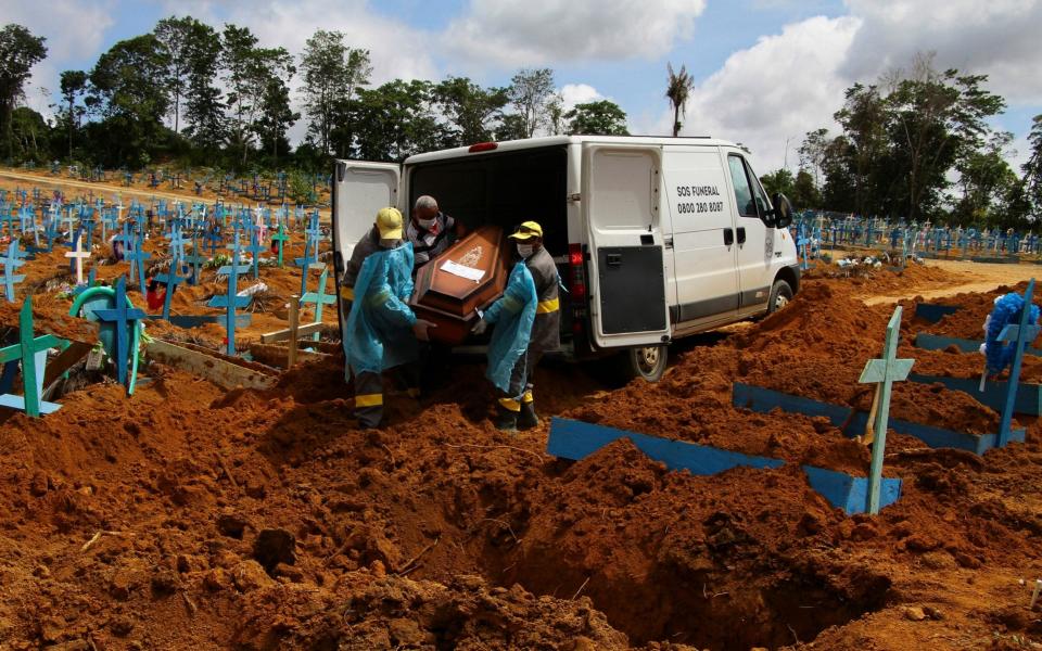 Cemetery workers carry the remains of 89-year-old Abilio Ribeiro, at the Nossa Senhora Aparecida cemetery in Manaus - Edmar Barros/AP