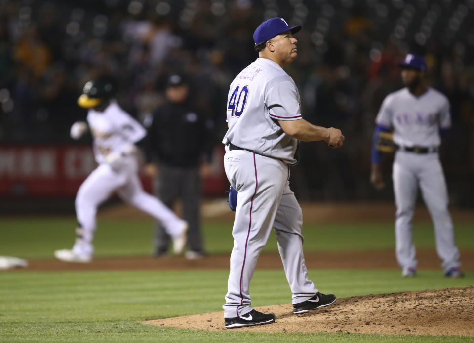 Texas Rangers' Bartolo Colon (40) walks back to the mound after giving up a three-run home run to Oakland Athletics' Ramon Laureano, left, in the sixth inning of a baseball game, Monday, Aug. 20, 2018, in Oakland, Calif. (AP Photo/Ben Margot)