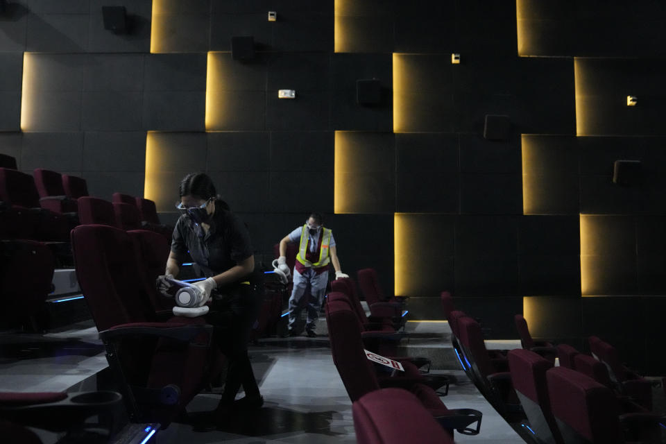 Employees sanitize a movie theatre as they prepare to reopen at the Eastwood mall in Quezon city, Philippines as government eases restrictions after a decline in Coronavirus cases in the country on Thursday, Oct. 14, 2021. Several businesses were allowed to reopen in the next days as the country tries to revive the economy which have suffered due to the lockdowns to prevent the spread of COVID-19. (AP Photo/Aaron Favila)