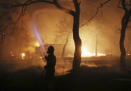 <p>A firefighter sprays water on the fire in the town of Mati, east of Athens, Monday, July 23, 2018. (Photo: Thanassis Stavrakis/AP) </p>