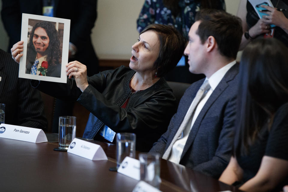 Pam Garozzo holds up a photograph of her late son Carlos, during a listening session on opioid and drug abuse with President Donald Trump, Wednesday, March 29, 2017, in the Cabinet Room of the White House in Washington. (AP Photo/Evan Vucci)