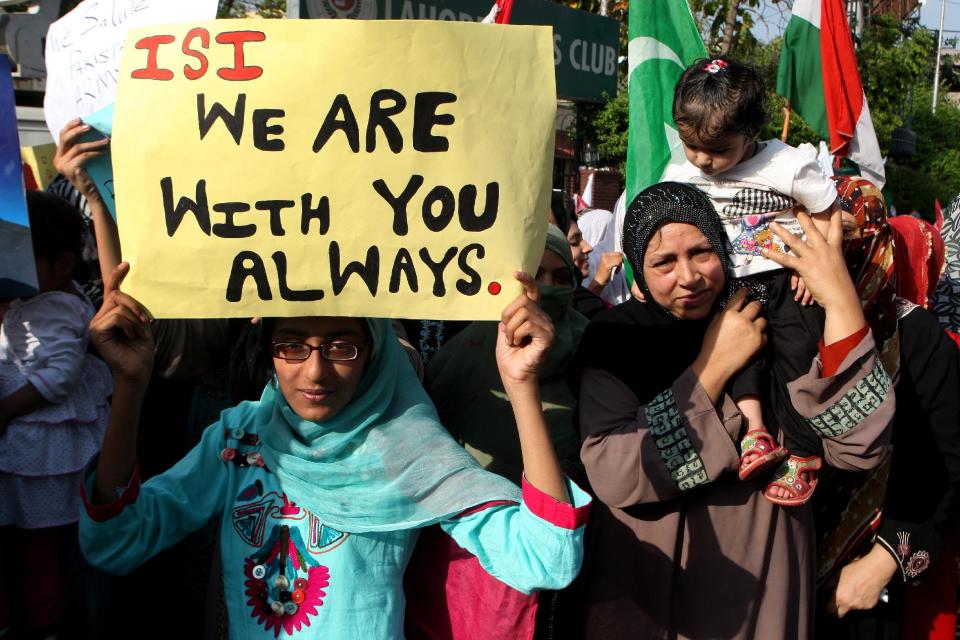 In this Friday, April 25, 2014 photo, supporters of a Pakistani religious group rally to support the Pakistan army and its Inter-Services Intelligence wing, ISI, in Lahore, Pakistan. A controversy has started as Pakistan's powerful military faces off with the country’s largest private television station over allegations that its forces were behind a shooting that seriously wounded Hamid Mir, one of its top anchors. But behind the chanting demonstrations and garish loyalty posters lies the deep challenge confronting Pakistan: Where does power lie in this country that’s undergone three military coups since independence, with its army or its nascent civilian government? (AP Photo/K.M. Chaudary)