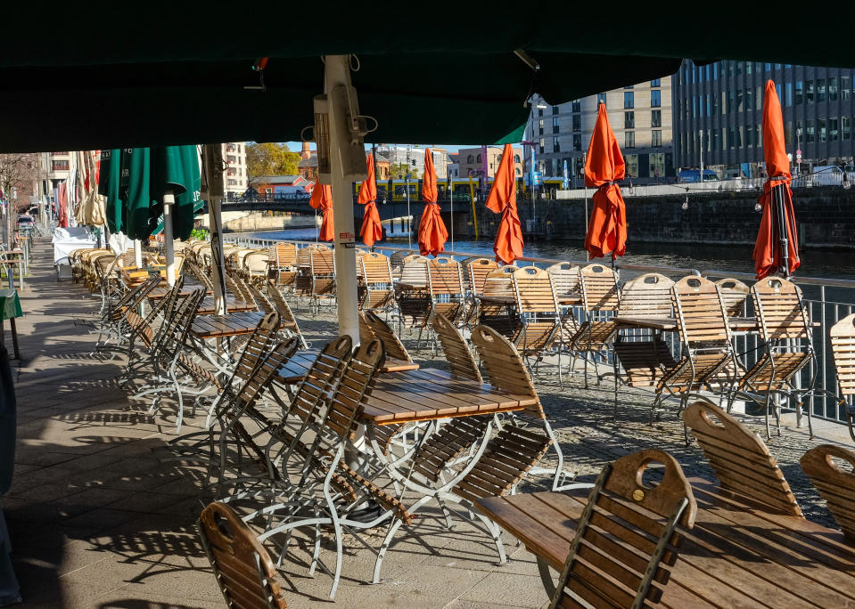 Closed parasols, empty tables and folded away chairs at a restaurant on the banks of the Spree, a tributary of River Havel, in Berlin. Photo: Jens Kalaene/Picture Alliance via Getty