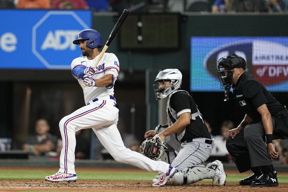 Texas Rangers' Marcus Semien follows through on a single as Chicago White Sox catcher Seby Zavala and umpire Emil Jimenez, right, look on in the sixth inning of a baseball game, Tuesday, Aug. 1, 2023, in Arlington, Texas. (AP Photo/Tony Gutierrez)