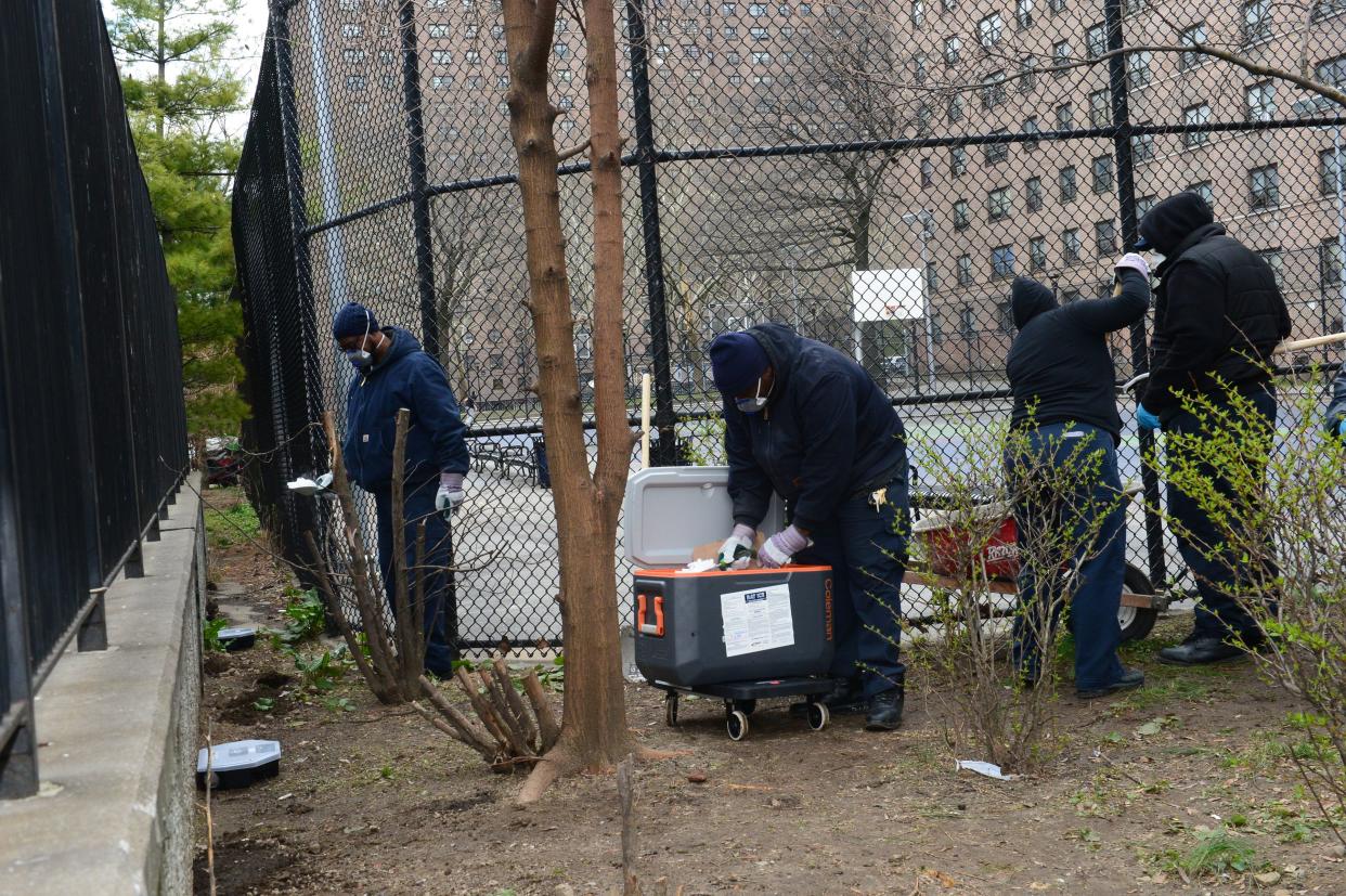 Workers apply dry ice to rat burrows in the Bushwick Houses on April 17, 2018. 