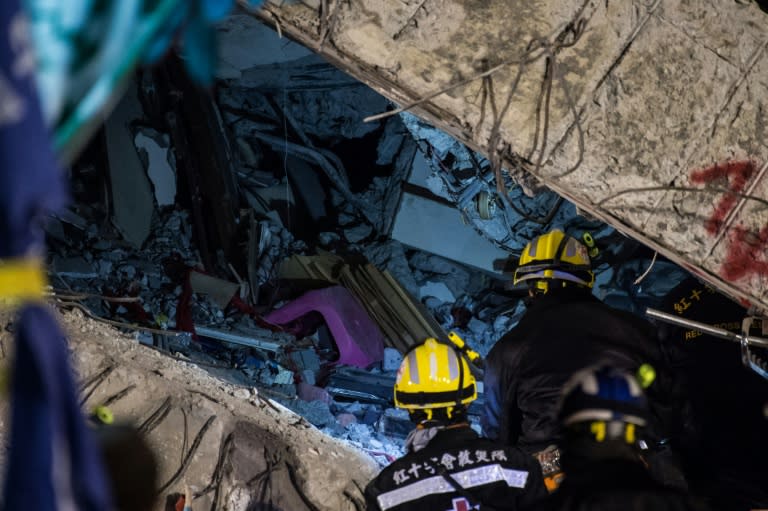 Rescue workers prepare to enter the remains of a flat during their search and rescue operation in the southern Taiwanese city of Tainan