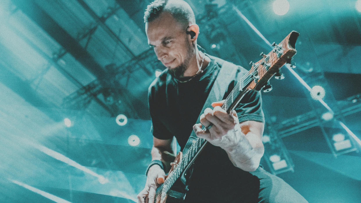  A close up of hard rock guitarist Mark Tremonti performing on stage. 