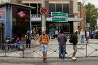 People wearing protective face masks stand at Usera neighbourhood in Madrid