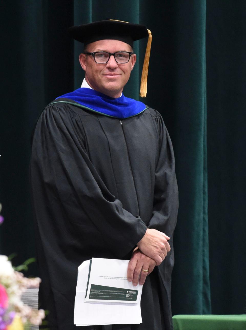 President Chris Cox waits on stage as graduates enter the gymnasium at Shelton State for the Spring Commencement Friday, May 5, 2023. Nearly 200 graduates participated in the ceremony with many more who did not. 