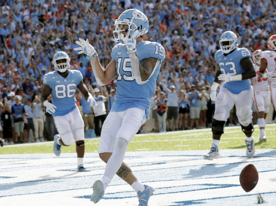 North Carolina's Beau Corrales (15) celebrates as he runs for a touchdown while teammates Carl Tucker (86) and Ed Montilus (63) look on during the second quarter of an NCAA college football game against Clemson in Chapel Hill, N.C., Saturday, Sept. 28, 2019. (AP Photo/Chris Seward)