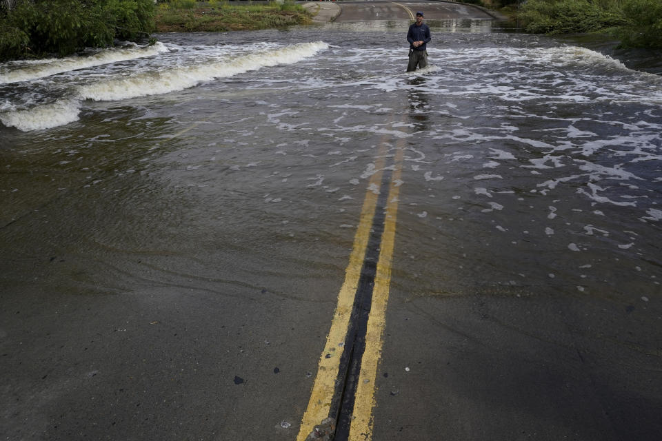 A television reporter stands in a flooded road after the passing of Tropical Storm Hilary, Monday, Aug. 21, 2023, in San Diego. Scientists figure a natural El Nino, human-caused climate change, a stubborn heat dome over the nation’s midsection and other factors cooked up Hilary’s record-breaking slosh into California and Nevada. (AP Photo/Gregory Bull)