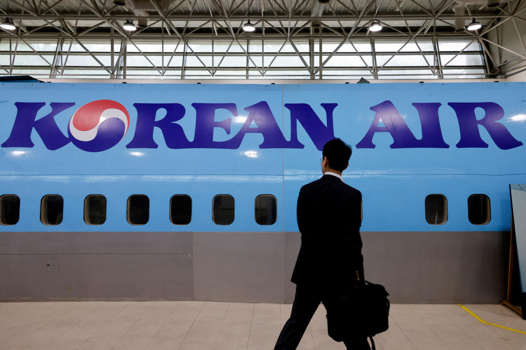 A man walks next to the logo of Korean Air airlines during an organised media tour, at the company's Cabin Crew Training Center in Seoul, South Korea, June 27, 2024. REUTERS/Kim Soo-hyeon