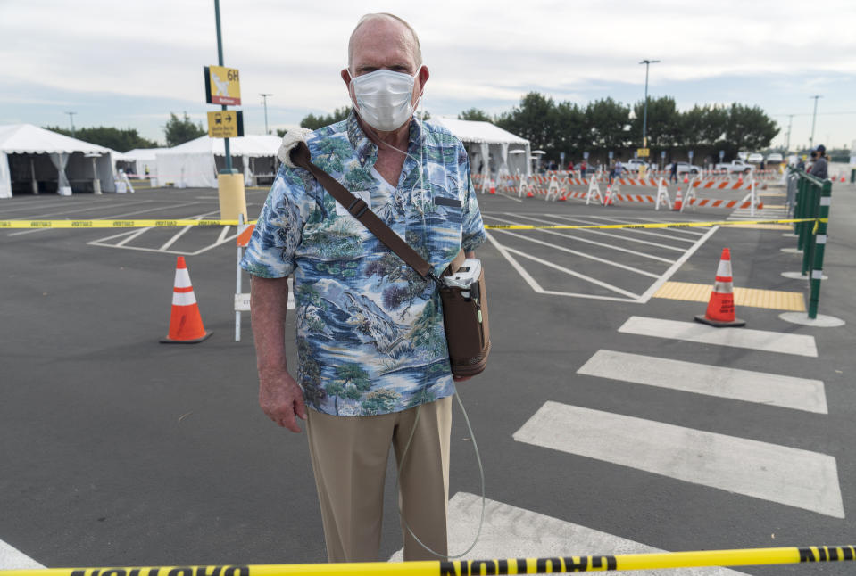 Gary Dohman, 81, from San Clemente Calif., who suffers from lung cancer, walks with an Oxygen machine, after getting a vaccine at the Disneyland Resort serving as a Super POD (Point Of Dispensing) COVID-19 mass vaccination site Wednesday, Jan. 13, 2021, in Anaheim, Calif. California is immediately allowing residents 65 and older to get scarce coronavirus vaccines, Gov. Gavin Newsom announced Wednesday. (AP Photo/Damian Dovarganes)