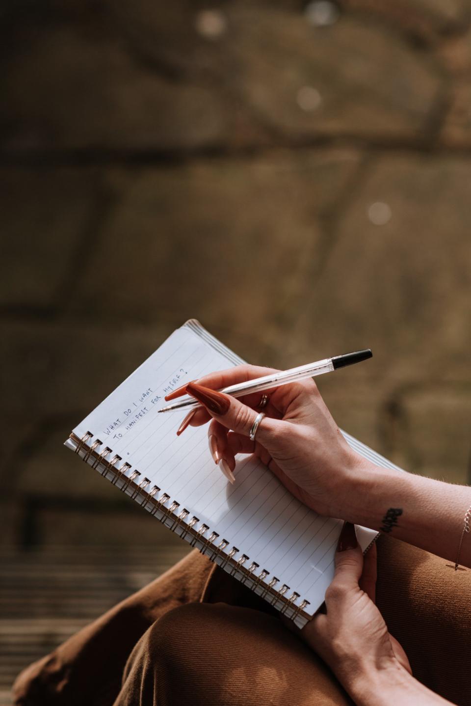 A hand writing in a journal