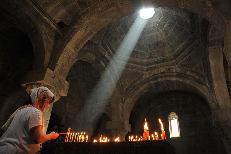 A visitor lights a candle in a church of the ancient Haghartsin monastery, some 110 km northeast of Yerevan, on June 8, 2013