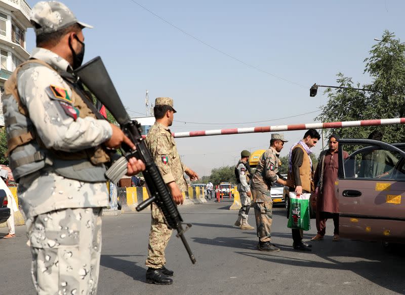 Afghan policemen stand guard at a check point in Kabul, Afghanistan