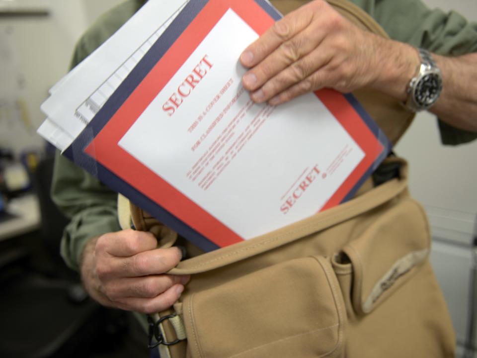 Man putting secret documents in bag