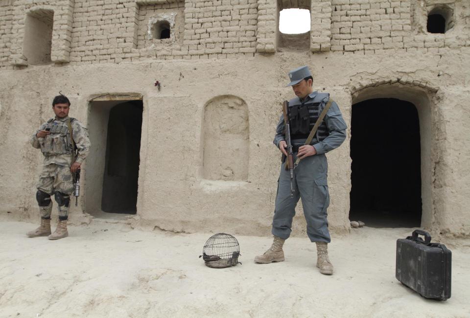 FILE - In this Sunday, March 11, 2012 file photo, Afghan security forces stand guard outside a home where witnesses say Afghans were killed by a U.S. soldier in Panjwai, Kandahar province south of Kabul, Afghanistan. U.S. Army Staff Sgt. Robert Bales was charged on Friday, March 23, 2012 with 17 counts of premeditated murder, a capital offense that could lead to the death penalty in the massacre of Afghan civilians, the U.S. military said. (AP Photo/Allauddin Khan, File)