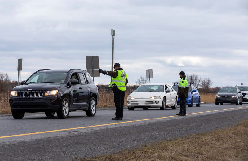 FILE PHOTO: Surete du Quebec police officers set up a checkpoint for drivers approaching the province from neighbouring Ontario