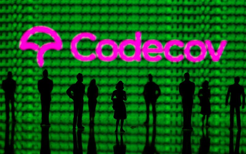 FILE PHOTO: Small toy figures are seen in front of the Codecov logo and cyber binary codes in this illustration