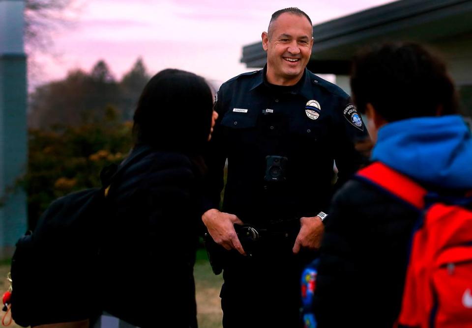 School Resource Officer Richard Sanders, with the Kennewick Police Department, talks with students outside Park Middle School in Kennewick in 2022.