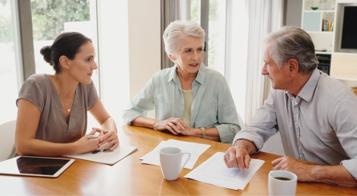 A couple being explained the tax consequences of transferring stock to a trust by their financial advisor