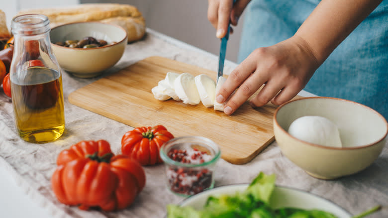 Person preparing Caprese salad