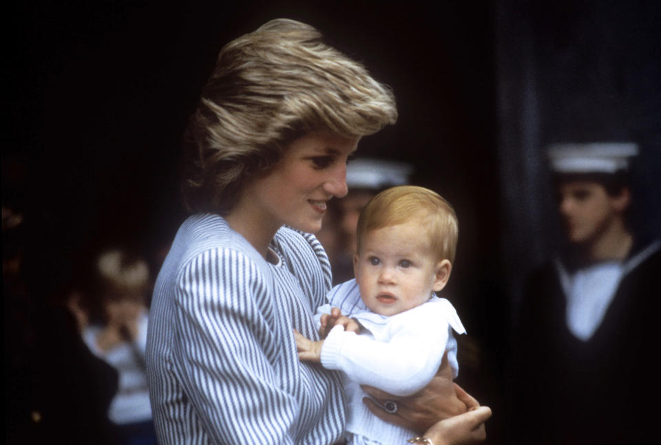 Diana carries baby Prince Harry in July 1985 - Credit: AP.