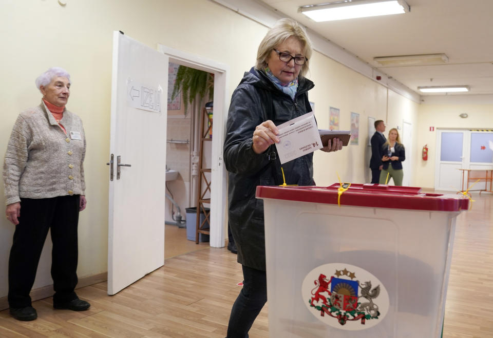 A woman casts her ballot at a polling station during general elections in Riga, Latvia, Saturday, Oct. 1, 2022. Polling stations opened Saturday in Latvia for a general election influenced by neighboring Russia’s attack on Ukraine, disintegration among the Baltic country’s sizable ethnic-Russian minority and the economy, particularly high energy prices. (AP Photo/Roman Koksarov)