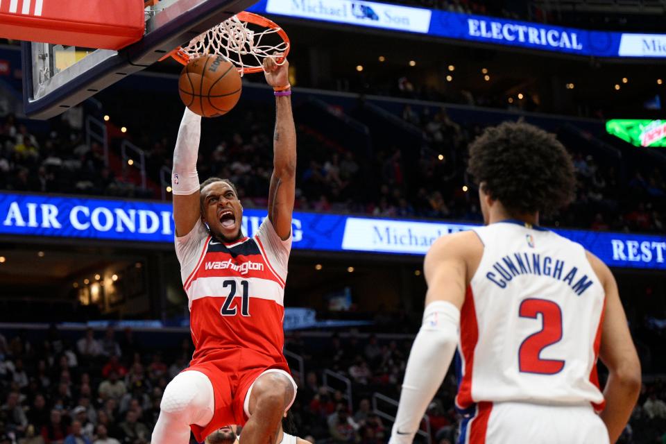 Washington Wizards center Daniel Gafford (21) dunks as Detroit Pistons guard Cade Cunningham (2) watches during the first half of an NBA basketball game Tuesday, March 1, 2022, in Washington.