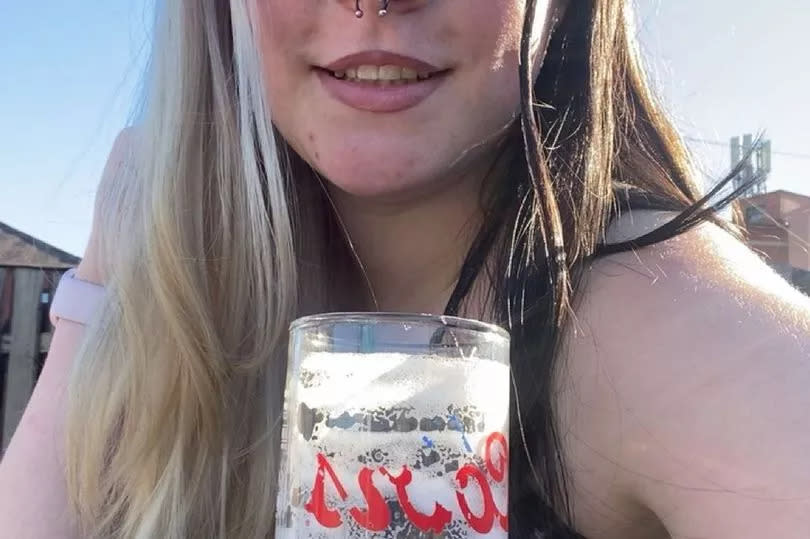 Eloise Paull posing for a photo with a beer