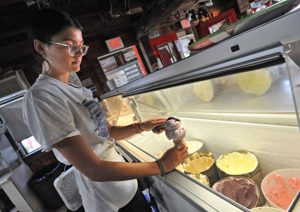 Charlotte Diamond, 18, of Duxbury, prepares an ice cream cone at FarFar's Danish Ice Cream Shop in Duxbury, Friday, Aug. 13, 2021.