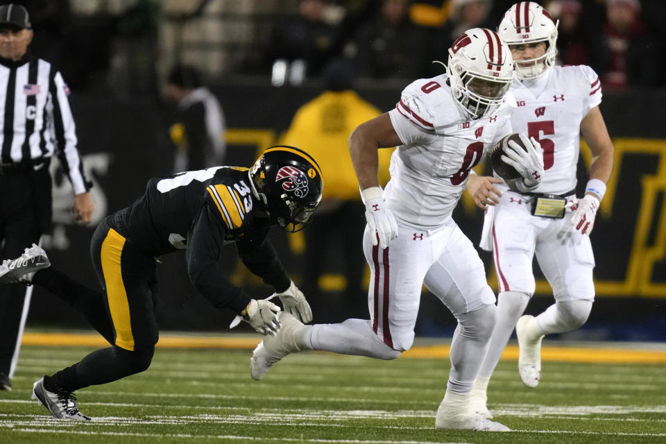 Wisconsin running back Braelon Allen (0) runs from Iowa defensive back Riley Moss (33) during the second half of an NCAA college football game, Saturday, Nov. 12, 2022, in Iowa City, Iowa. Iowa won 24-10. (AP Photo/Charlie Neibergall)