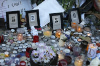 FILE - In this Nov.15, 2015 file photo, pictures of victims are placed behind candles outside the Bataclan concert hall in Paris.For more than two weeks, dozens of survivors from the Bataclan concert hall in Paris have testified in a specially designed courtroom about the Islamic State’s attacks on Nov. 13, 2015 – the deadliest in modern France. The testimony marks the first time many survivors are describing – and learning – what exactly happened that night at the Bataclan, filling in the pieces of a puzzle that is taking shape as they speak. (AP Photo/Christophe Ena, File)