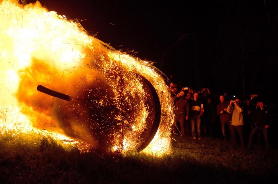 An oak wheel stuffed with straw is set on fire and rolled down a hill to celebrate the Easter Wheel (Osterraeder) tradition in Luedge, Germany