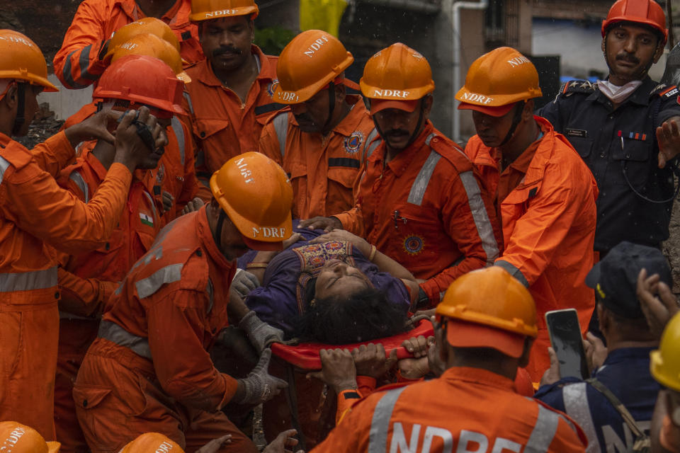 A woman is carried on. stretcher after being rescued from the debris of a four-story residential building that collapsed in Mumbai, India, Tuesday, June 28, 2022. At least three people died and more were injured after the building collapsed late Monday night. (AP Photo/Rafiq Maqbool)