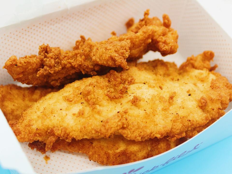 chick fil a chicken tenders in box on blue background