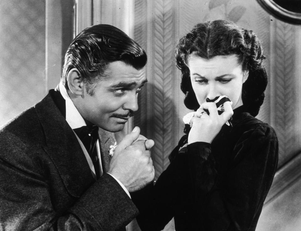 American actor Clark Gable (1901 - 1960) in his role as Rhett Butler kissing the hand of a tearful Scarlett O'Hara, played by Vivien Leigh in 'Gone With The Wind'.   (Photo by Hulton Archive/Getty Images)